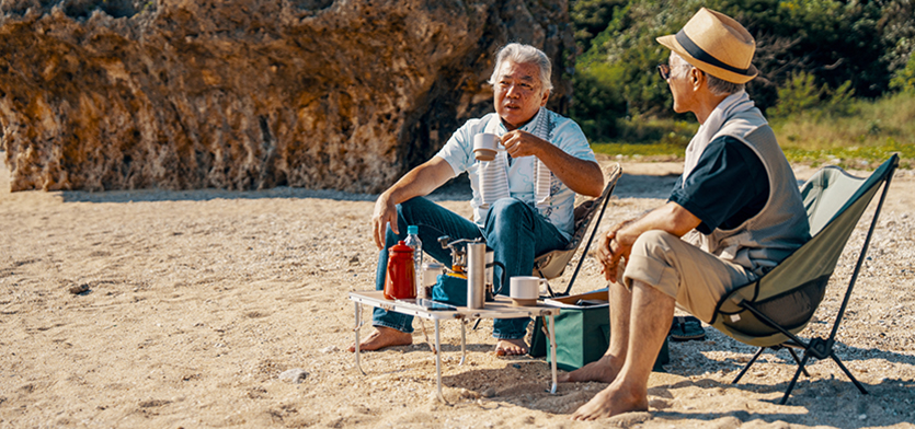Two tourists sitting in lawn chairs on a beach