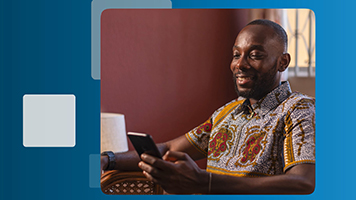 A man smiles while looking at his phone
