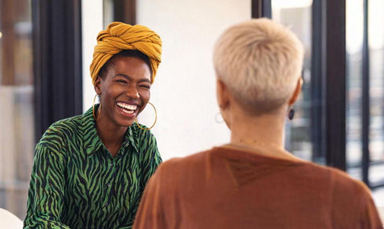 Two happy women look over their plans together
