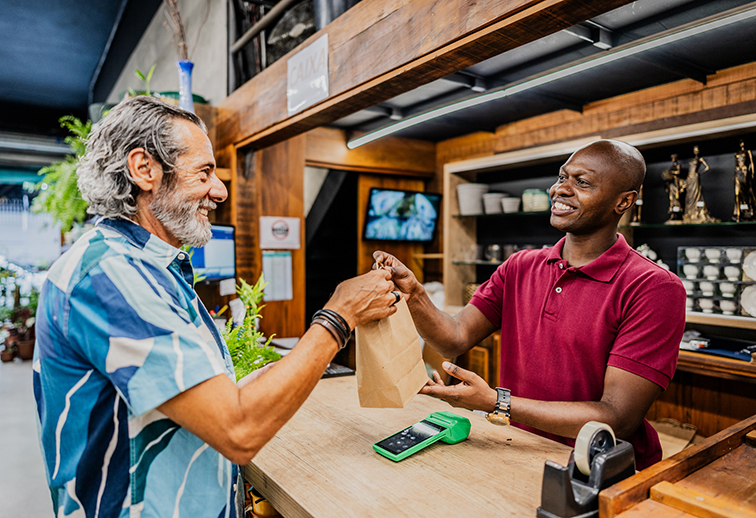 Blue Cross Well-Being Bag being handed over a lunch counter between an employee and a customer