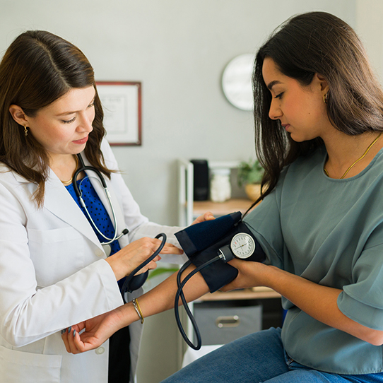 A doctor checking a woman's blood presure A doctor checking a woman's blood presure