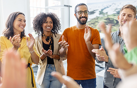 Four smiling coworkers standing in a row