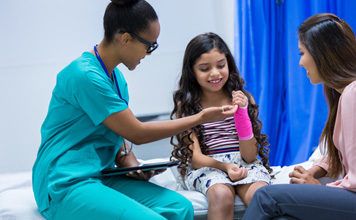 A doctor visits with a mother and child