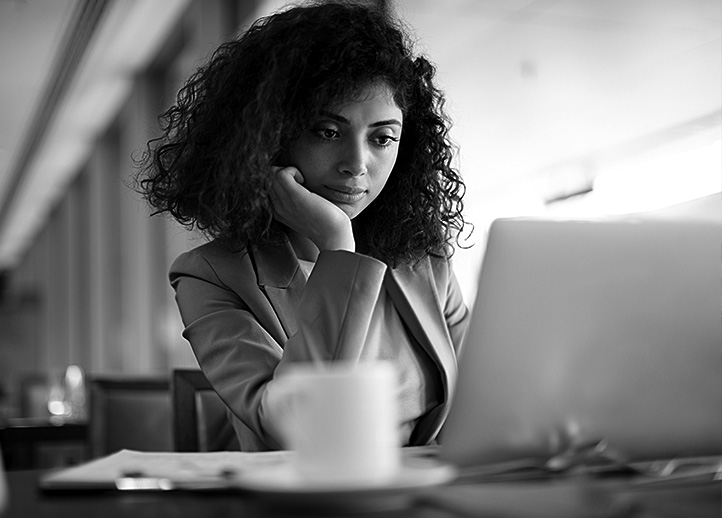 A woman looks at her laptop computer