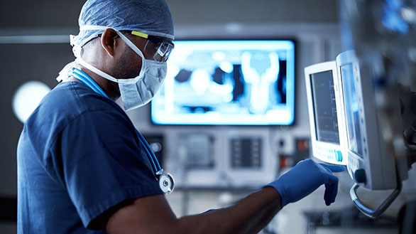 A doctor looks at information on a screen. 