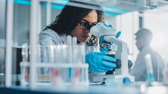 A doctor looks through a telescope for results. 