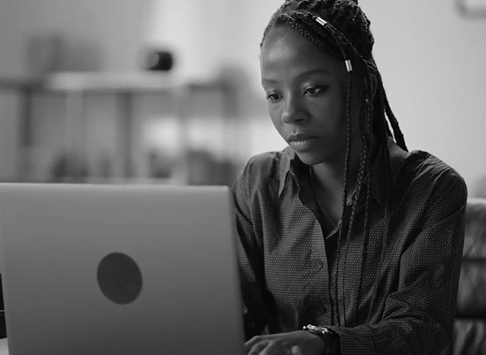 A woman types on her laptop computer