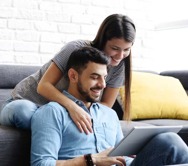 Couple in living room using online account on tablet device