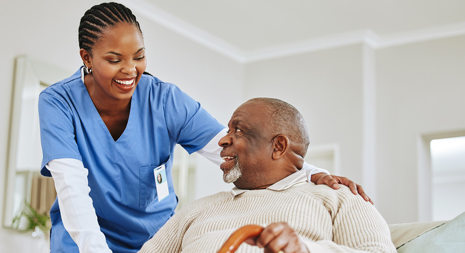 A nurse smiles as she talks with her patient. 