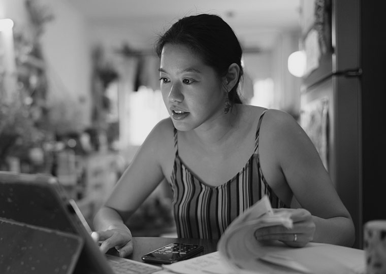 Person working with computer and papers at desk