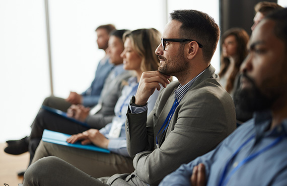 People sitting in a business meeting listening to a speaker