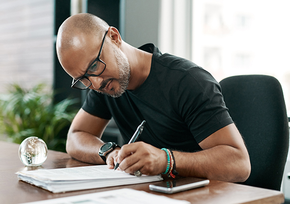 A man takes notes about his health insurance. 
