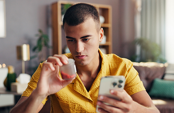 man looking at prescription bottle