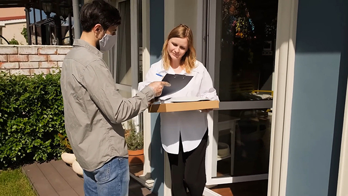 A woman receives a delivery at home. 