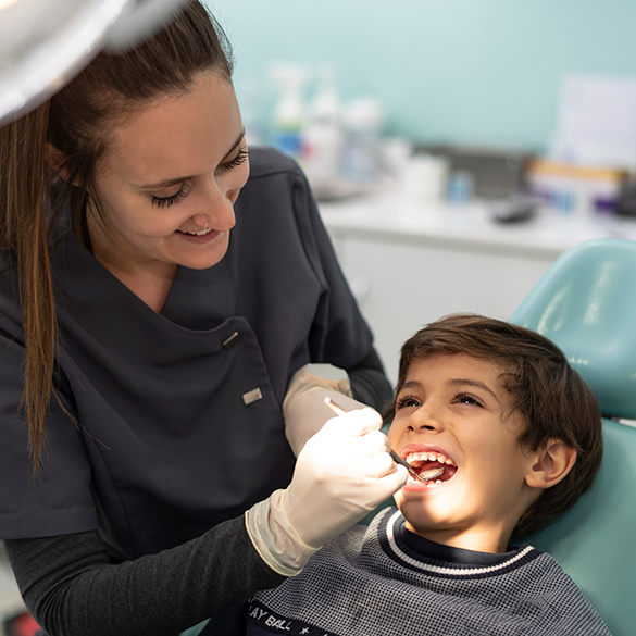 A dentist examines a child's teeth.