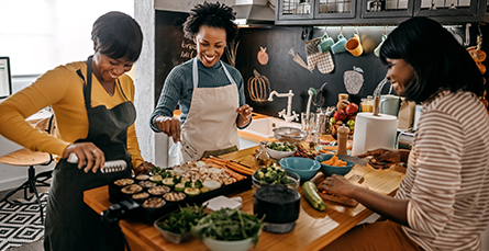 three women gathered in a kitchen baking cookies
