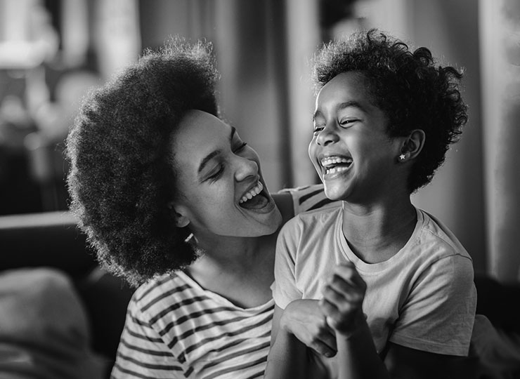 A mother and child smile and laugh.
