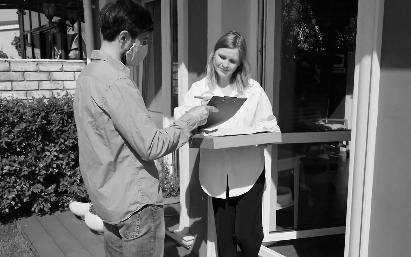 A woman receives a delivery at home. 