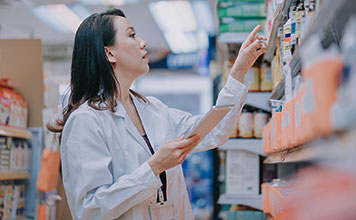 A pharmacist looking at the shelves in a pharmacy