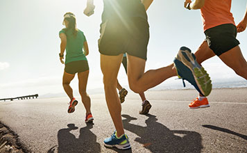 A group of people run outside. 