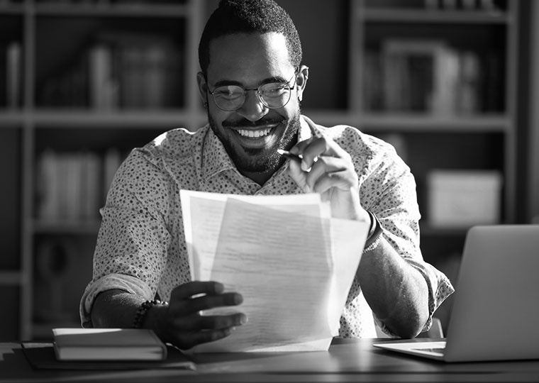 man reading documents at desk