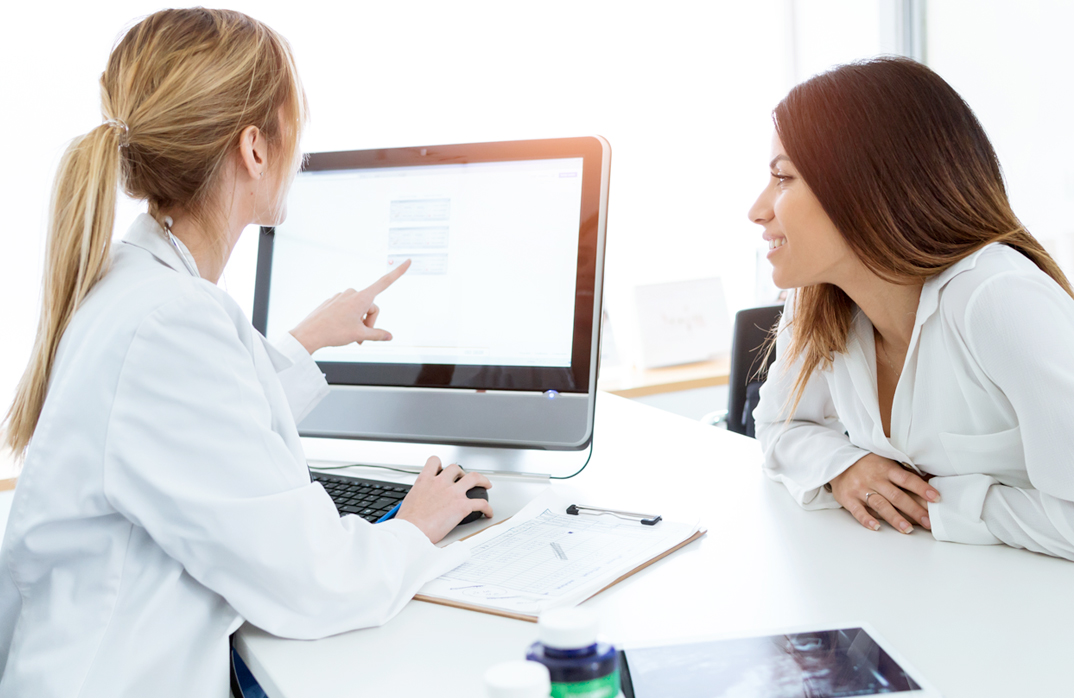 A doctor reviews information with a patient. 