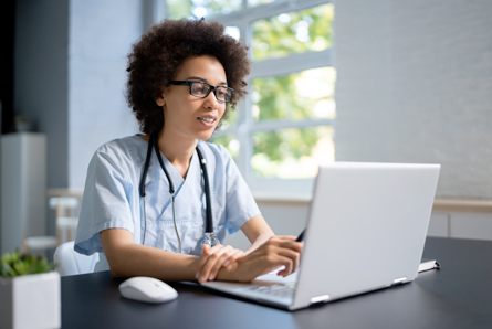  A doctor reads information on their laptop