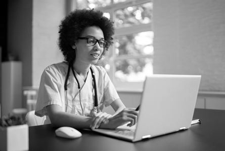  A doctor reads information on their laptop