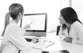 A provider looks at a computer with a woman