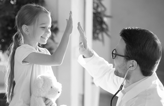 A little girl gives her doctor a high five. 