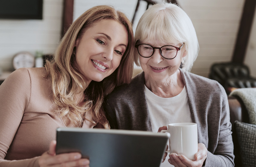 A woman and her mother look over papers in front of a laptop computer as they look for Blue Cross Blue Shield of Michigan plans for Medicare, individuals and families..