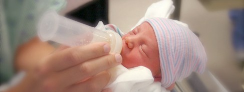 A newborn infant being fed